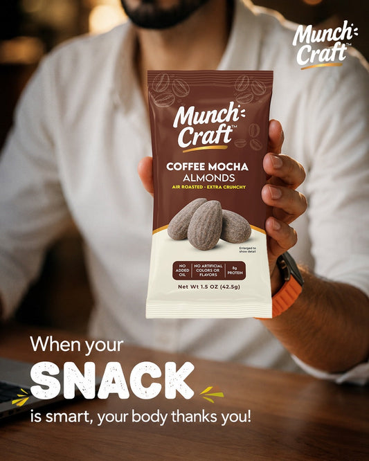 Man at a desk holding a Munch Craft Coffee Mocha Almonds snack pouch